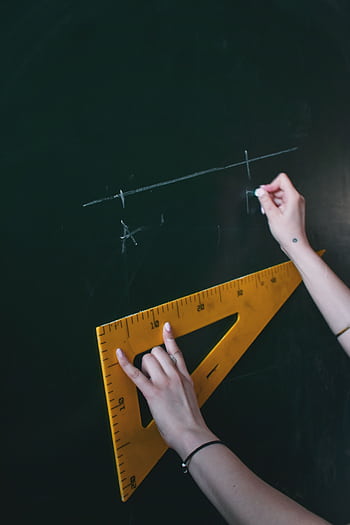 Two hands drawing a line with chalk on a blackboard using a triangle ruler HD phone wallpaper