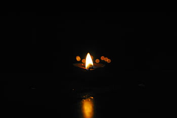 Captivating close-up of a candle flame illuminating darkness, highlighting serenity and warmth. HD wallpaper