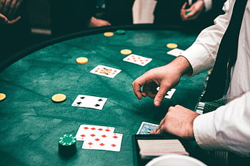 Casino scene with dealer and players, featuring cards and chips, creating a suspenseful atmosphere. HD wallpaper