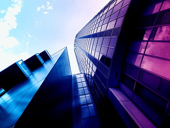Low angle shot of modern skyscrapers with reflective glass facades and vibrant colors in an urban setting. HD wallpaper