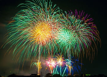 Bright and colorful fireworks explode against a dark night sky, perfect for holiday celebrations. HD wallpaper