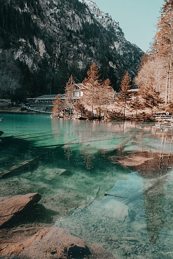 Tranquil alpine lake with clear reflections in Kandergrund, Switzerland's stunning wilderness. HD phone wallpaper