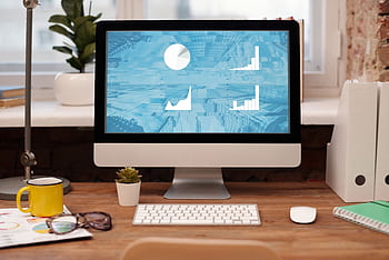 Stylish home office setup with , plant, and eyeglasses on a wooden desk. HD wallpaper