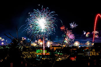 Colorful fireworks light up the night sky over Mödling, Austria in a festive celebration. HD wallpaper