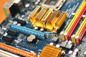 Detailed close-up of a computer motherboard showcasing various electronic components. HD wallpaper