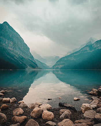 Panoramic view of Lake Louise with mountain reflections and overcast sky. HD phone wallpaper