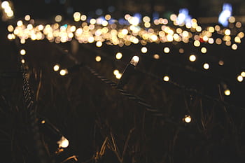 Close-up of glowing string lights with beautiful bokeh effect at night. HD wallpaper