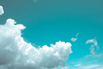 Bright and serene view of fluffy white clouds against a vibrant blue sky. HD wallpaper