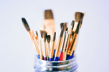 Collection of various paintbrushes in a jar ready for artistic projects. HD wallpaper