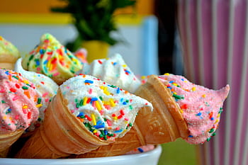 Vibrant ice cream cones topped with colorful sprinkles, perfect for summer treats. HD wallpaper