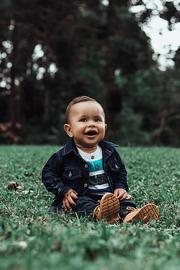 Cute baby sitting and smiling on grass in São Paulo park, Brazil. HD phone wallpaper