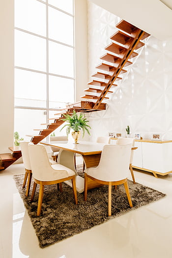 Bright and stylish dining area featuring contemporary furniture and a sleek wooden staircase. HD phone wallpaper