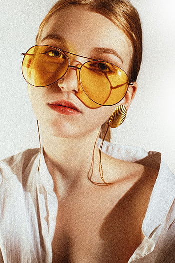 Chic portrait of a woman in yellow sunglasses and statement earrings. HD phone wallpaper