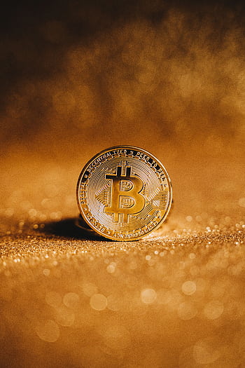 Close-up of a golden Bitcoin with a sparkling background, symbolizing digital finance. HD phone wallpaper