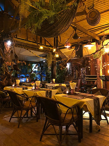 Charming rustic restaurant setting with warm lighting and decorative plants, perfect for a cozy dining experience. HD phone wallpaper