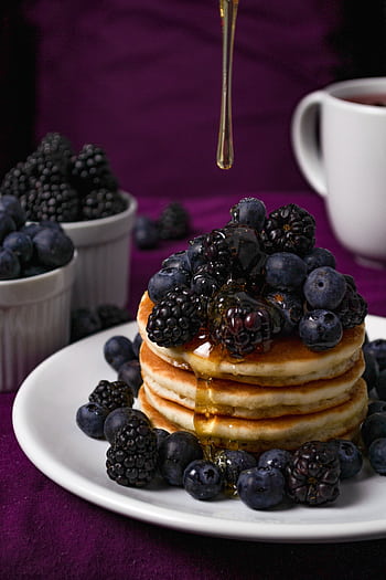 Stack of fluffy pancakes topped with fresh blackberries and blueberries, drizzled with honey, perfect for a delicious breakfast. HD phone wallpaper