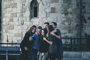 Group of friends enjoying a moment together while taking a selfie outdoors. HD wallpaper