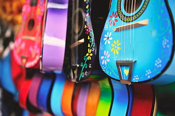 Vibrant close-up of artistically decorated acoustic guitars with floral patterns. HD wallpaper