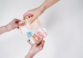 Close-up of hands exchanging euro bills, symbolizing finance and transaction. HD wallpaper