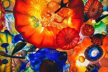 A vivid display of colorful abstract glass art with dynamic shapes and lighting. HD wallpaper