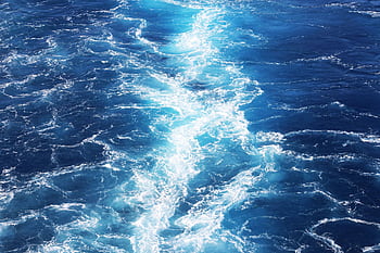Captivating view of ocean waves showcasing the vibrant deep blue sea and white foam patterns. HD wallpaper