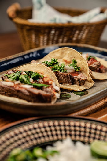 Three mouth-watering Mexican tacos served on a platter with fresh cilantro and onions. HD phone wallpaper