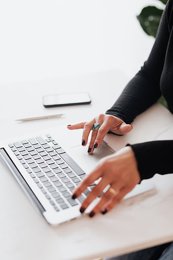 A businesswoman's hands typing on a laptop at a bright, modern workspace. HD phone wallpaper