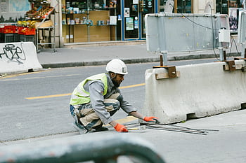 A construction worker operates on a city street in Paris, France, showcasing urban development. HD wallpaper