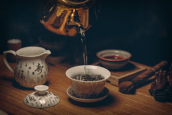 Artistic depiction of a traditional Chinese tea ceremony with porcelain teaware and hot water pour. HD wallpaper