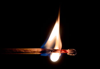 A stunning macro shot capturing a single matchstick in flames against a black background. HD wallpaper