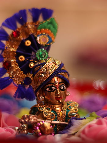 Close-up of a vibrant Hindu deity figurine, showcasing intricate details and cultural significance. HD phone wallpaper