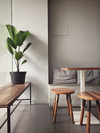 A minimalist, modern indoor seating area with wooden furniture and a potted plant, perfect for a cozy home interior. HD phone wallpaper