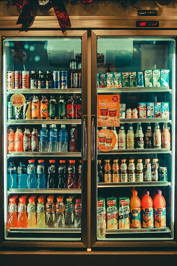 Assorted chilled beverages displayed in a store refrigerator showcasing various drink options for sale. HD phone wallpaper