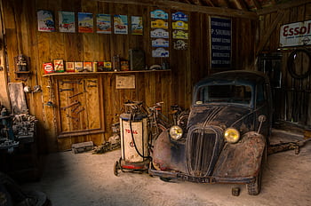Old car in a rustic garage, surrounded by vintage signs and tools. HD wallpaper