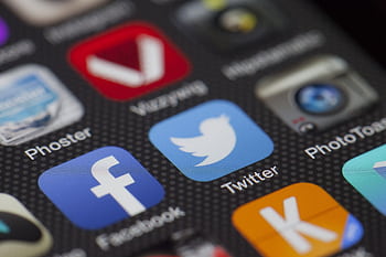 A detailed close-up of social media icons on a smart screen, including Facebook and Twitter. HD wallpaper