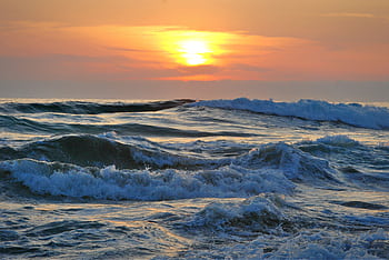 Vibrant sunset over ocean waves on the Chilean coast, showcasing a beautiful seascape. HD wallpaper
