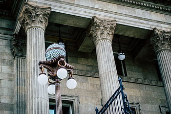 An elegant view of classic architectural columns with an antique street lamp, ideal for urban landscapes. HD wallpaper