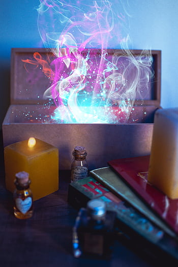A magical scene with a glowing box, colorful smoke, candles, and potion bottles. HD phone wallpaper
