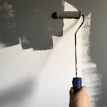 A hand painting a wall gray with a roller during a house renovation project. HD phone wallpaper