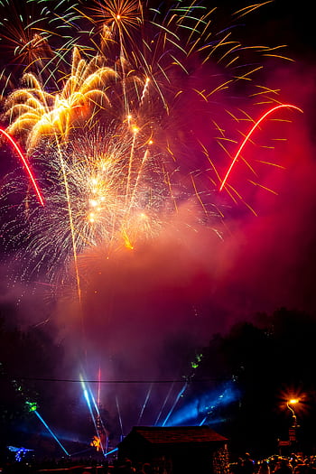 A dazzling explosion of colorful fireworks lighting up the night sky during a festive celebration. HD phone wallpaper