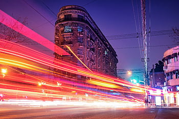 A dynamic long exposure of traffic light streaks against historic Shanghai architecture at night. HD wallpaper
