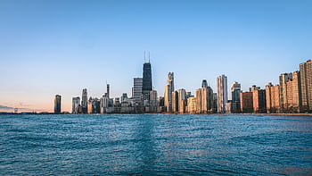 Stunning view of Chicago's skyline at dawn, reflecting over a calm waterfront. HD wallpaper