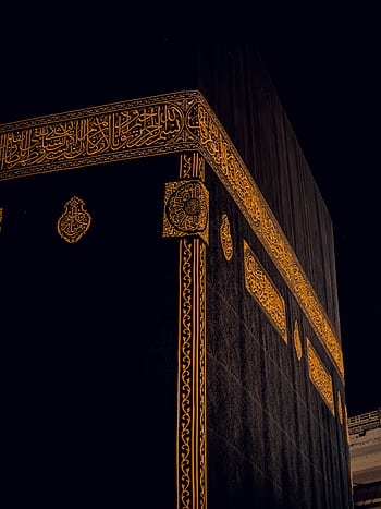 Close-up of the Kaaba in Mecca, Saudi Arabia, showing intricate golden patterns at night. HD phone wallpaper