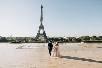 A bride and groom sharing a romantic moment in front of the iconic Eiffel Tower in Paris. HD wallpaper
