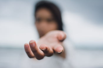 A soft focus highlighting a reaching hand, symbolizing connection or help. HD wallpaper