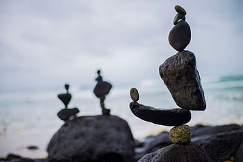 Artistic rock balancing on a serene beach in Fingal Head, NSW, Australia. HD wallpaper