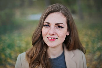 Close-up portrait of a smiling woman with freckles and long hair in a Budapest park during fall. HD wallpaper