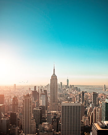 Breathtaking view of New York City's skyline featuring the iconic Empire State Building at sunrise. HD phone wallpaper