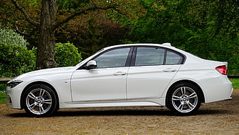 Side view of a sleek white luxury sedan parked outdoors, showcasing elegance and style. HD wallpaper