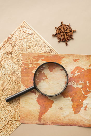 High-angle view of a vintage map with magnifying glass and compass for exploration themes. HD phone wallpaper